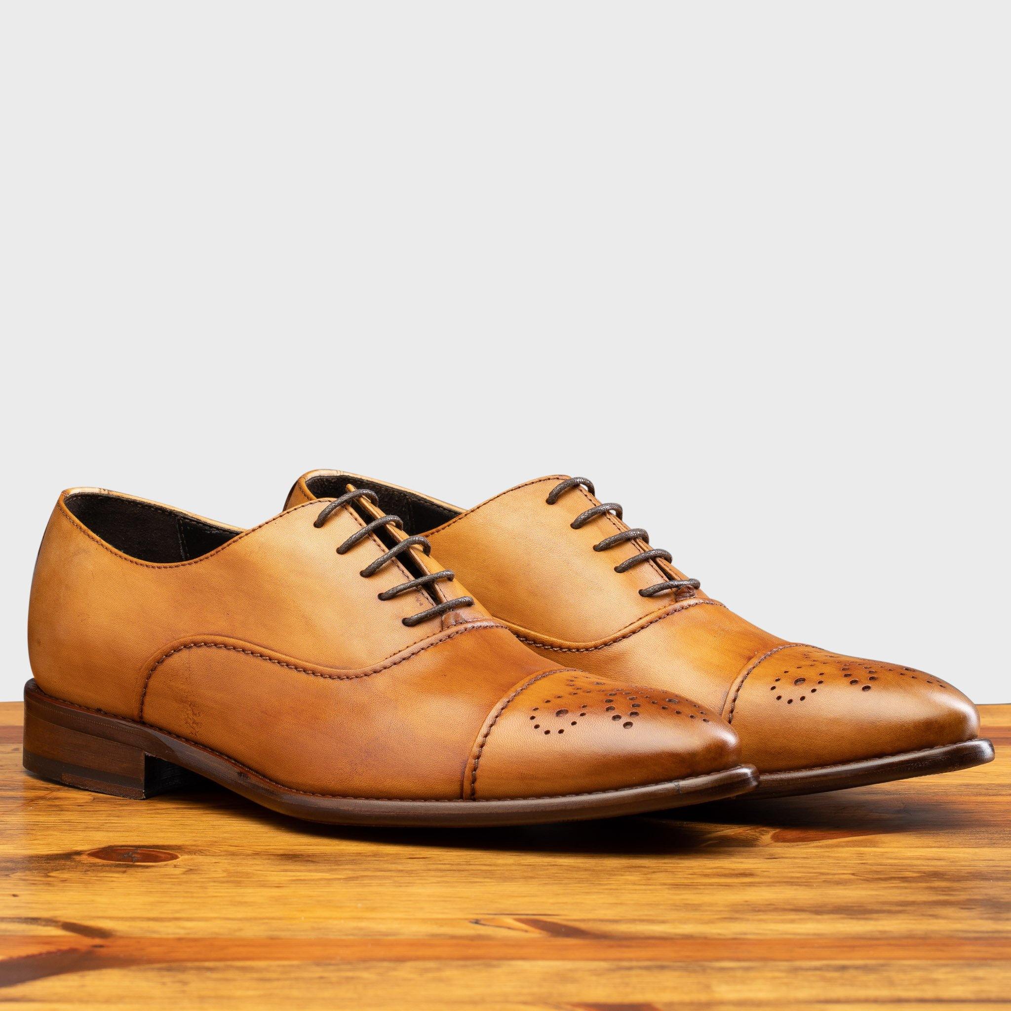 Pair of 2361 Calzoleria Toscana Dark Caramel Cayenne Calf Cap Toe on top of a wooden table